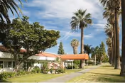 Exterior view of Villa Health Care Center with orange awning and palm trees