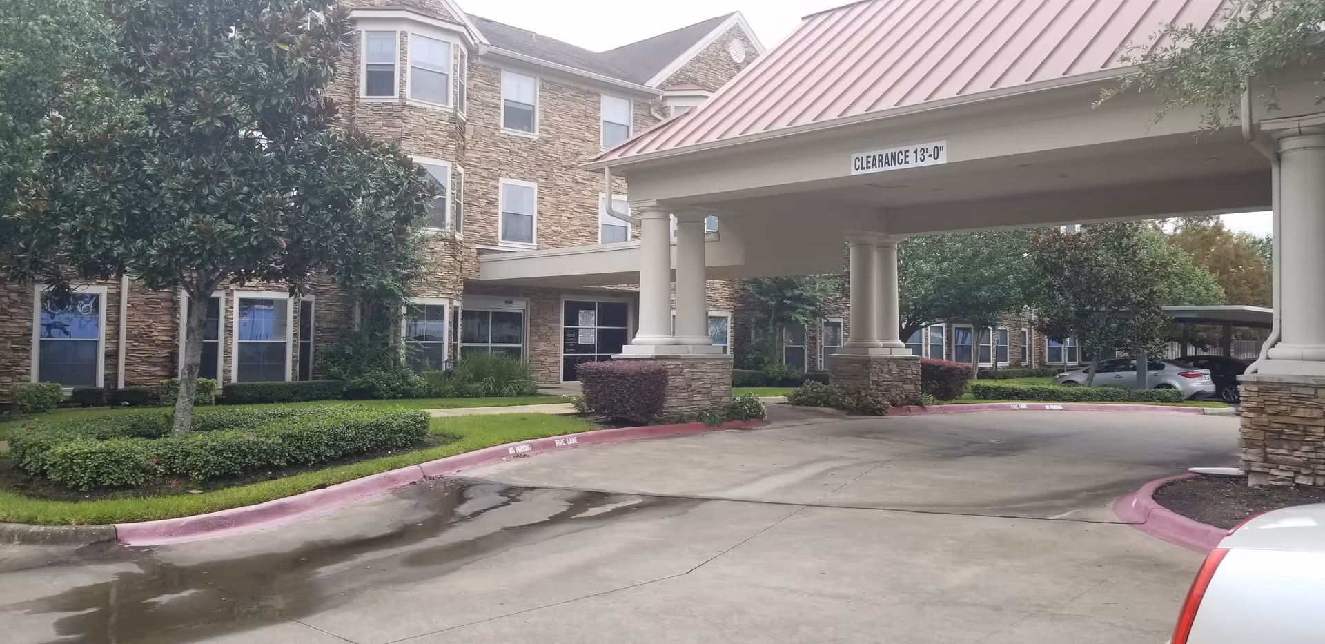 Exterior view of The Salvation Army Evangeline Booth Apartments entrance with drive and landscaping.