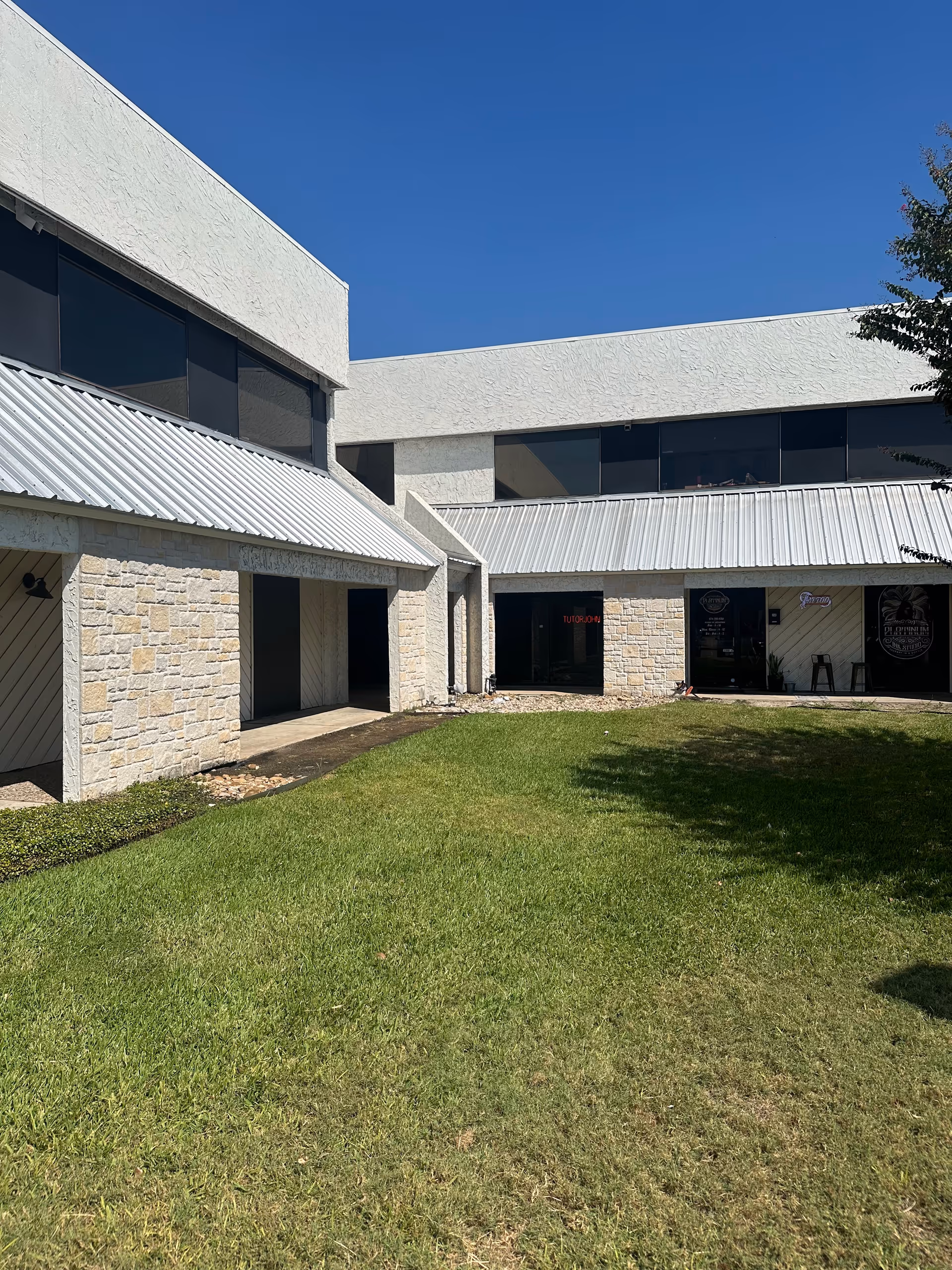 Exterior of CareCo senior living facility with stone walls, large windows, and a green lawn.