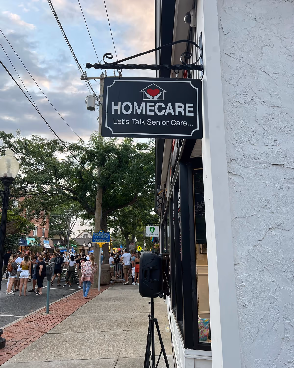 A storefront sign reading HOMECARE hangs from a building beside a busy street.