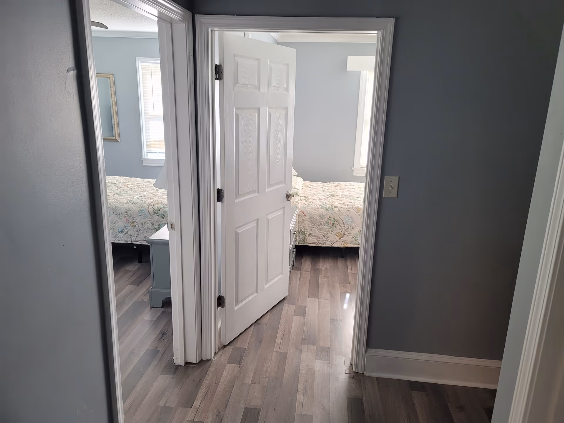 Interior hallway with doors open to two furnished bedrooms.