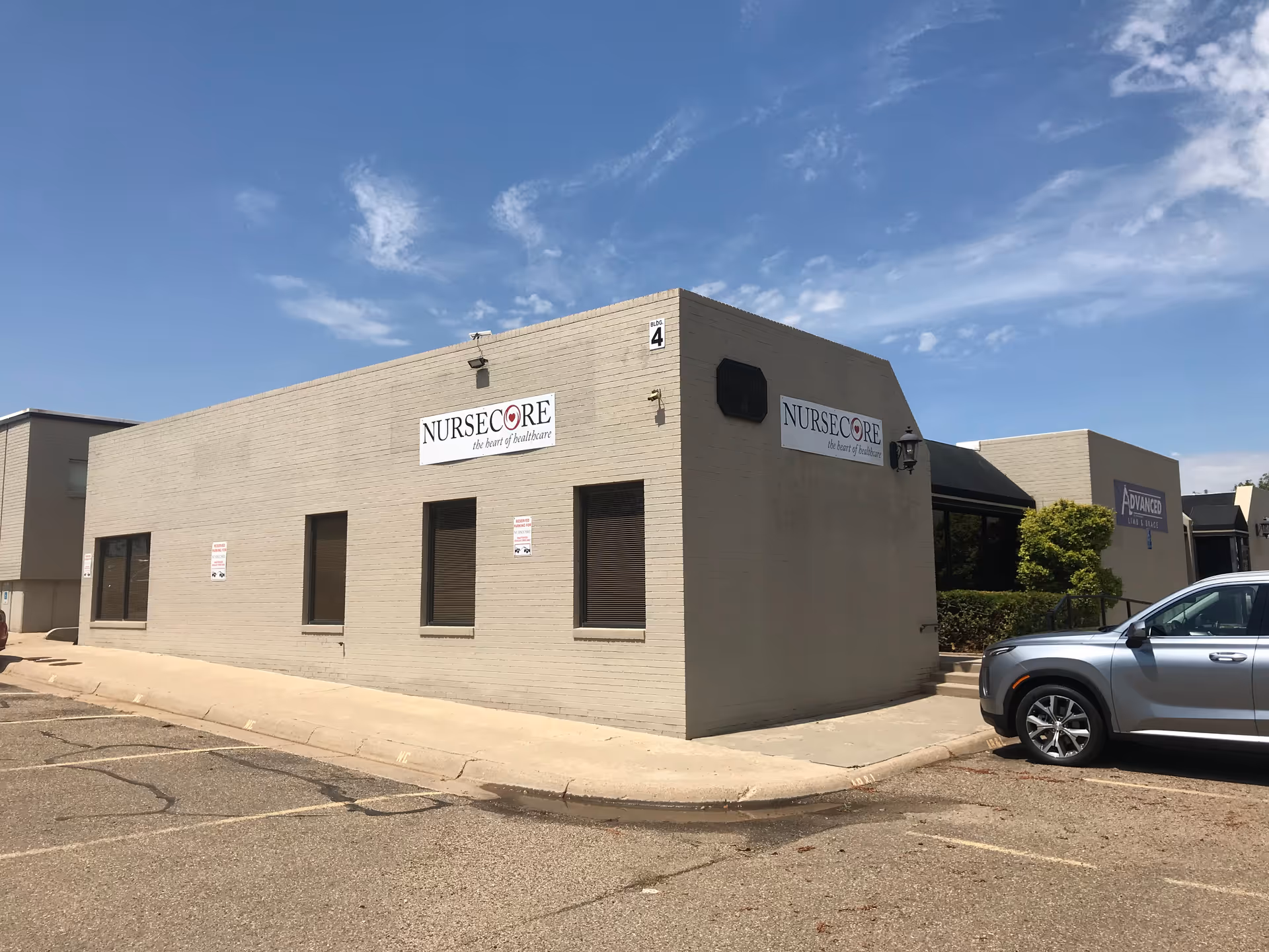 Exterior view of NurseCore Amarillo building with a parked car beside the entrance