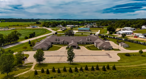 Aerial view of Prairie View Manor, a single story senior living facility with parking and lawns.
