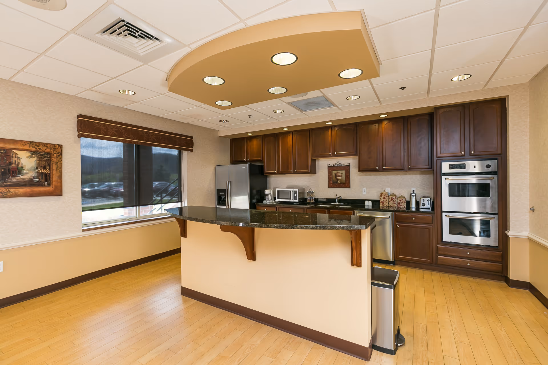 Modern residential kitchen with dark wood cabinets, stainless appliances, and a central breakfast island.