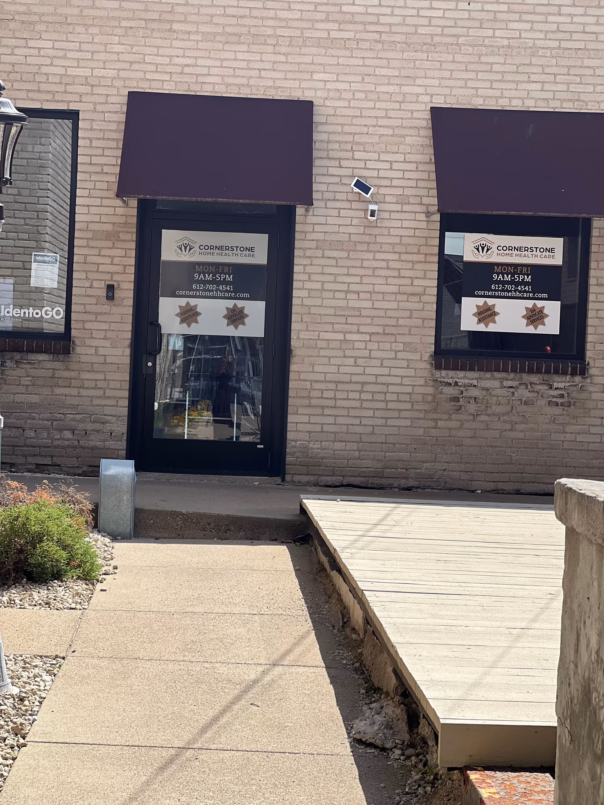 Exterior brick building with two doors, purple awnings, and Cornerstone Home Health Care signage.