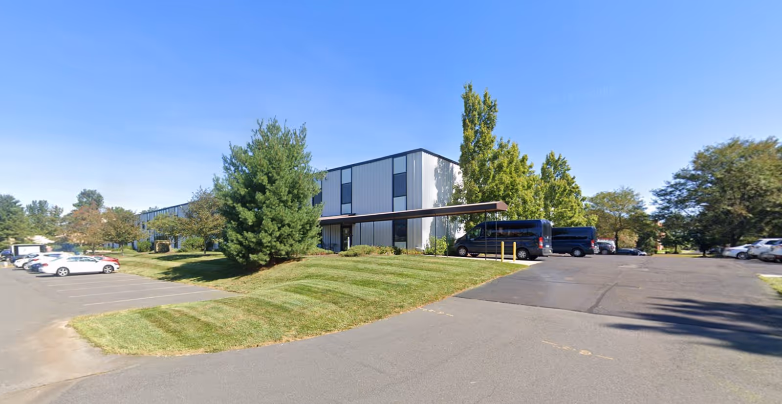 Modern two-story building with a parking lot and well-kept landscaping.