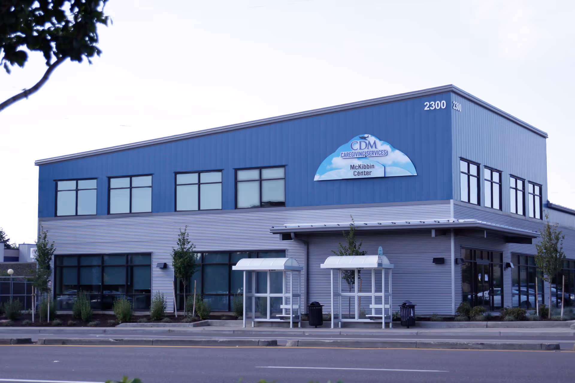 Blue two-story facility with CDM Caregiving Services sign and front entrances.