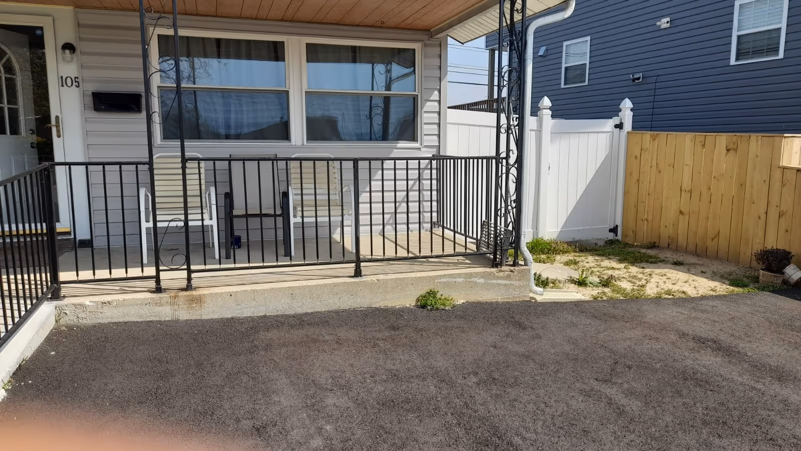 Front porch of a senior living facility with two chairs and a railing.