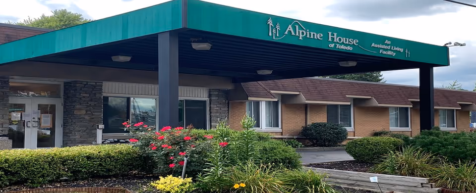 Exterior view of Alpine House of Toledo with a green canopy and landscaped entrance.