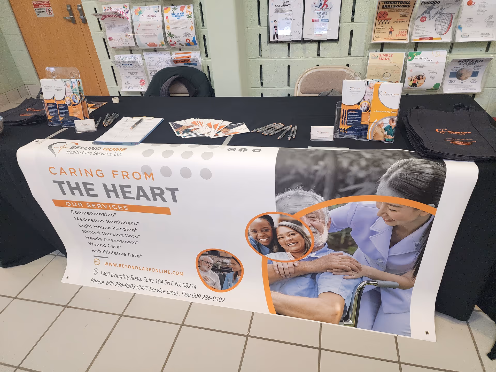 Promotional table displaying a banner, brochures, and pens for Beyond Home Health Care.