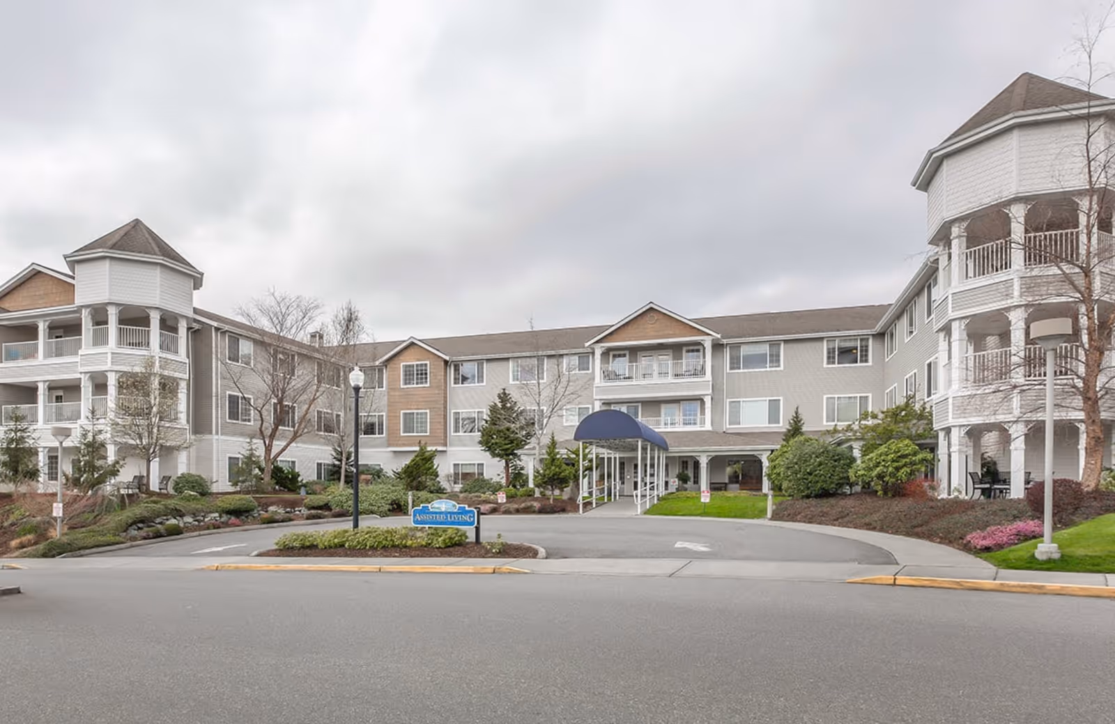 Exterior view of Regency on Whidbey, a multi-wing senior living building with a curved driveway.
