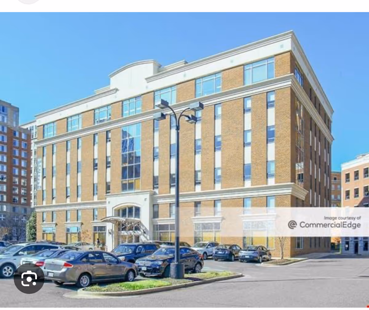 Brick, multi-story senior living facility exterior with cars parked in front