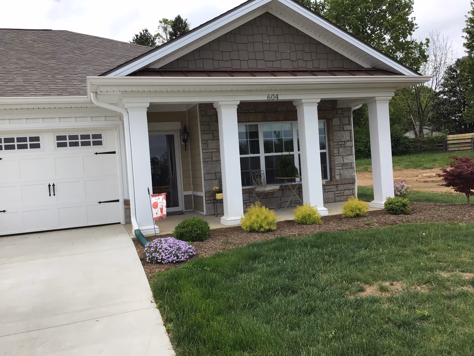 Front view of Daisy Hill Senior Living building with porch, columns, and landscaped yard.