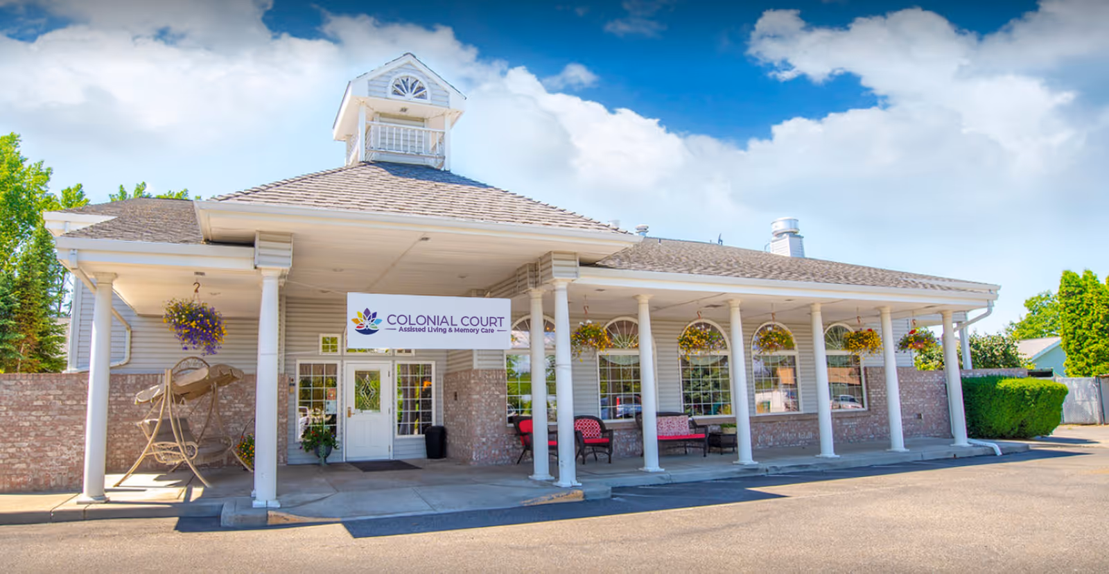 Colonial Court senior living facility exterior with a columned porch and sign.