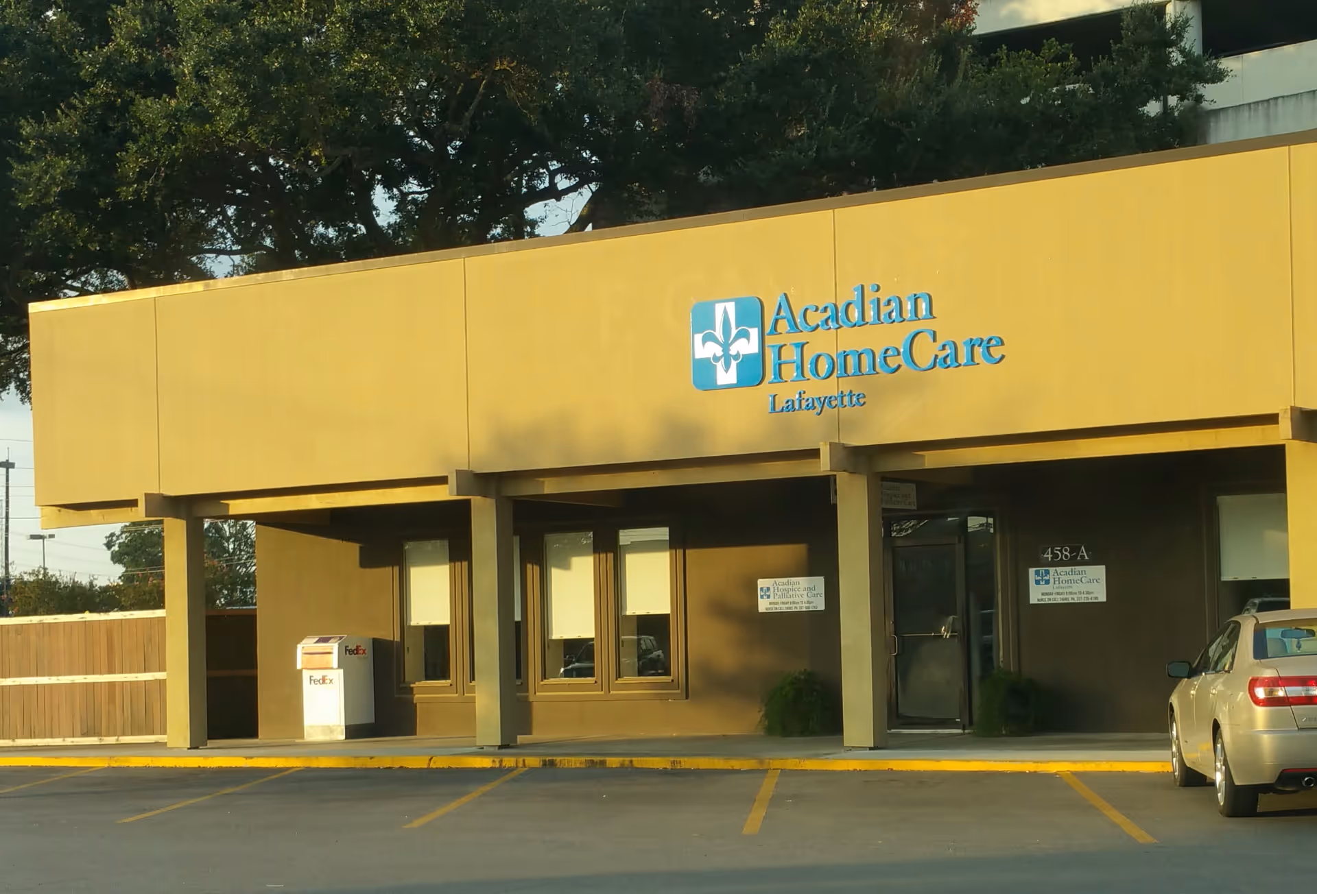 Tan building facade with Acadian HomeCare Lafayette signage and a car parked outside.