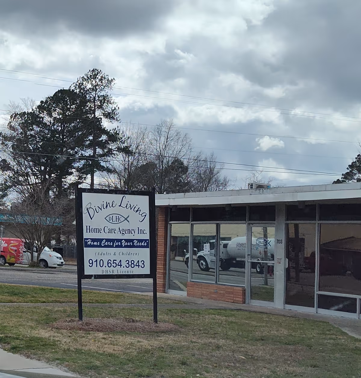 Front view of a single-story building with a Divine Living sign and glass storefront.