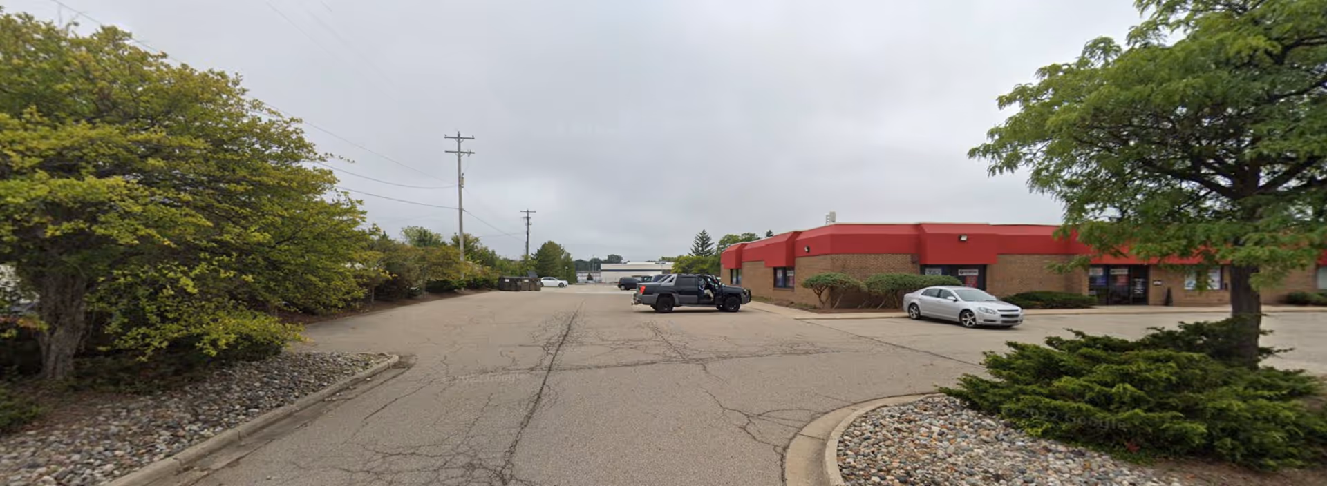 Exterior view of the Home Care Alternatives facility with a red awning and parked cars.