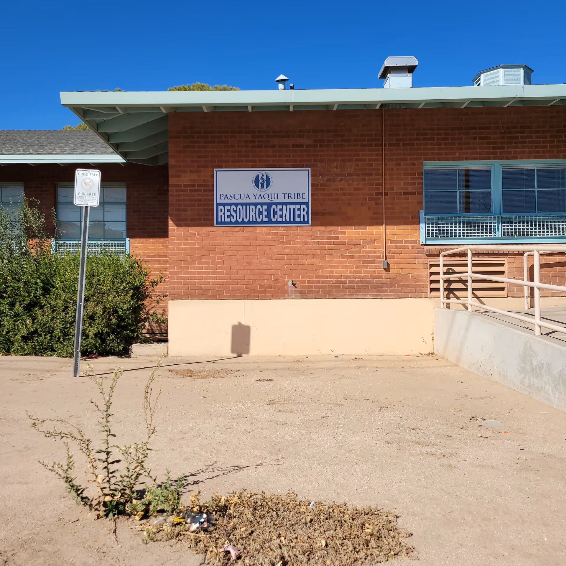 Exterior brick building with a blue Resource Center sign and a wheelchair ramp.