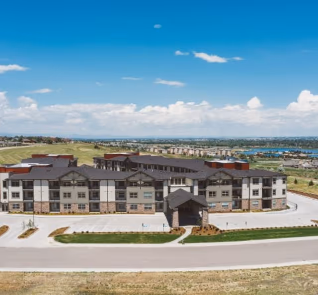 Exterior view of Eagle's Peak senior living facility with entrance and parking lot.