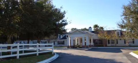 Exterior view of a Brookdale senior living facility with a white facade and entrance.
