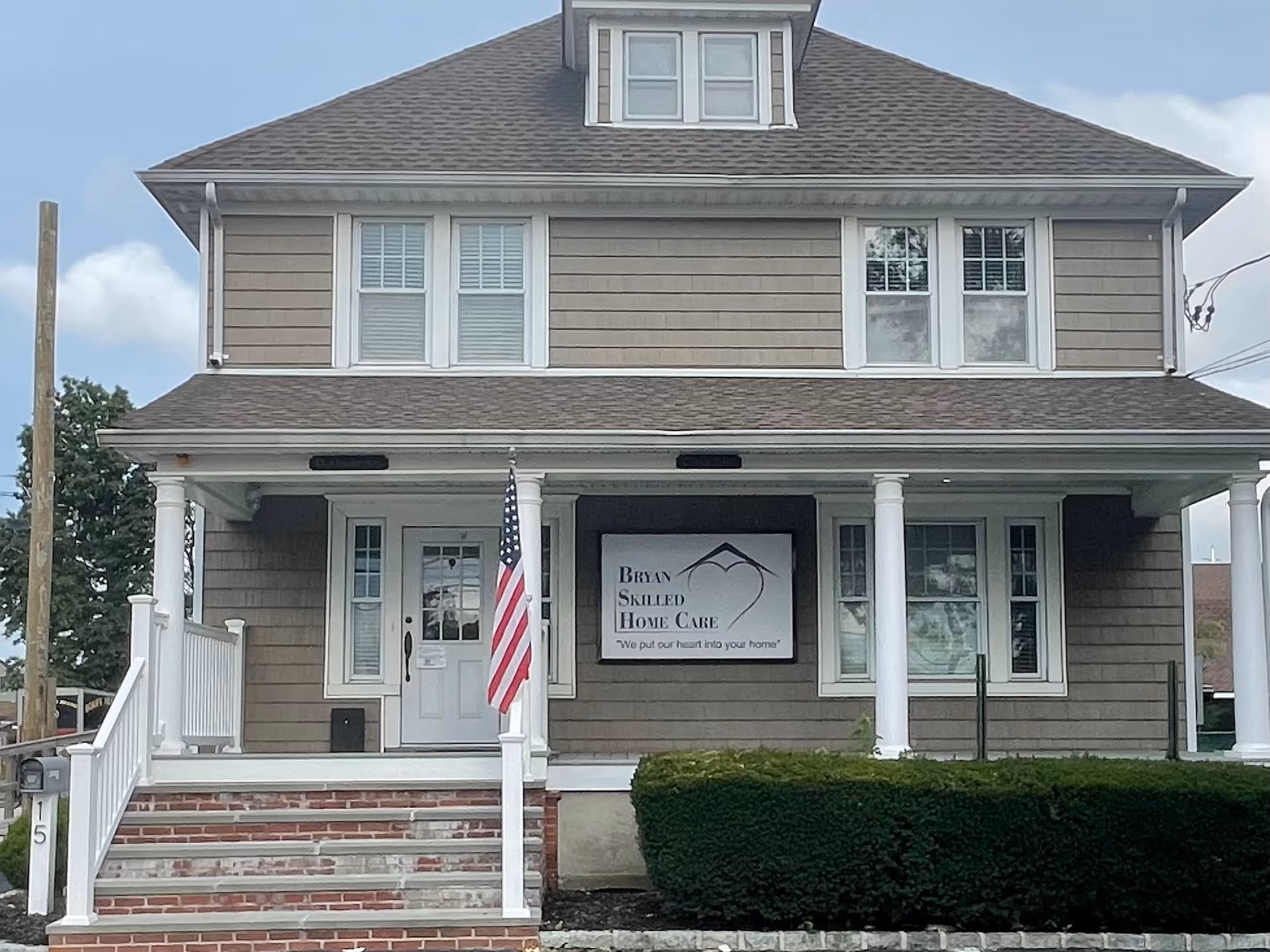 Front view of a two-story home with a Bryan Skilled Home Care sign on the porch.
