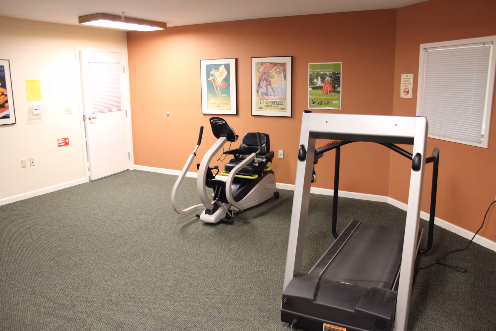 Indoor exercise room with a treadmill and stationary bike.