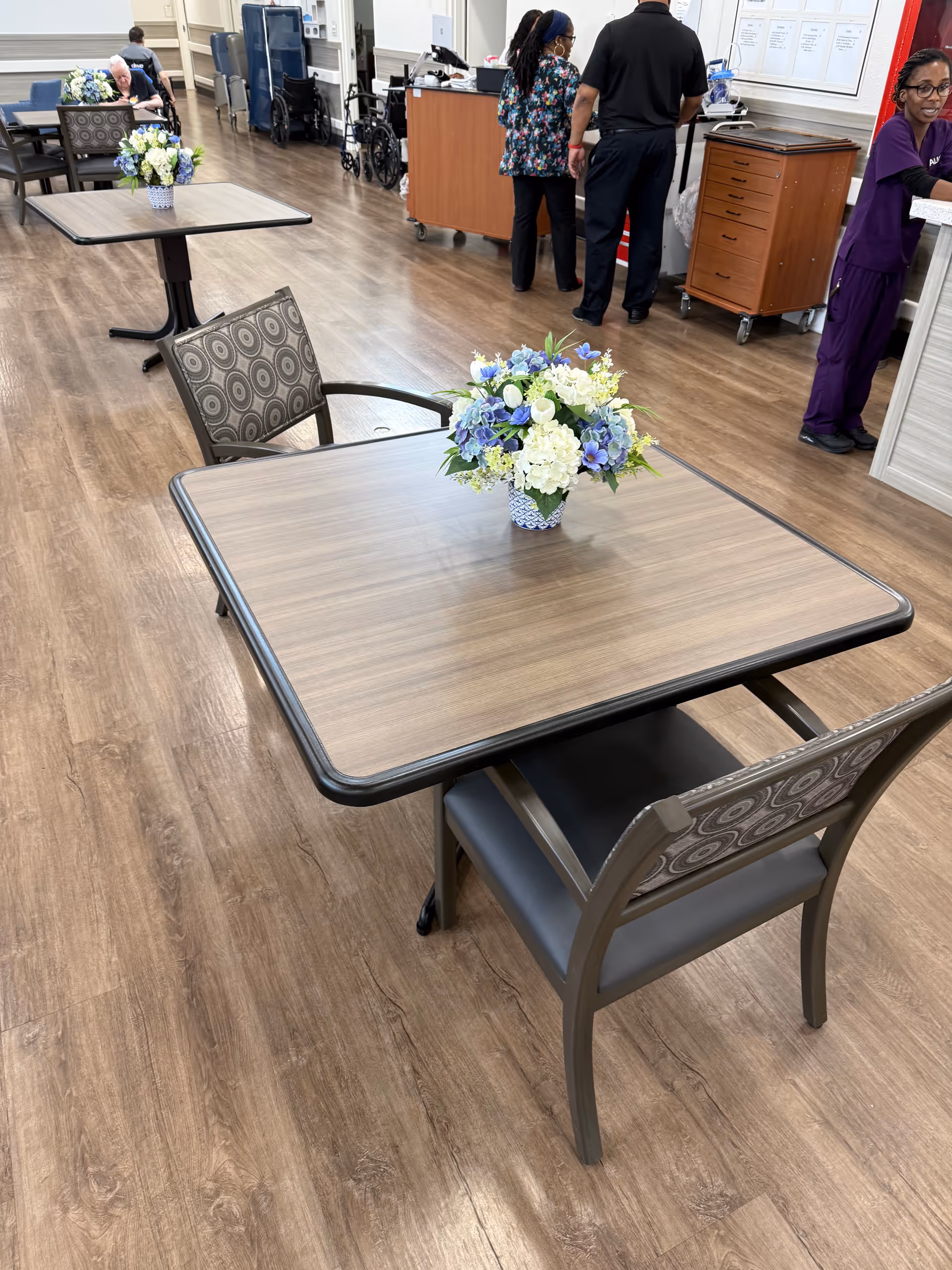 A dining room in Avante at Mt Dora with tables, chairs, and floral centerpieces.