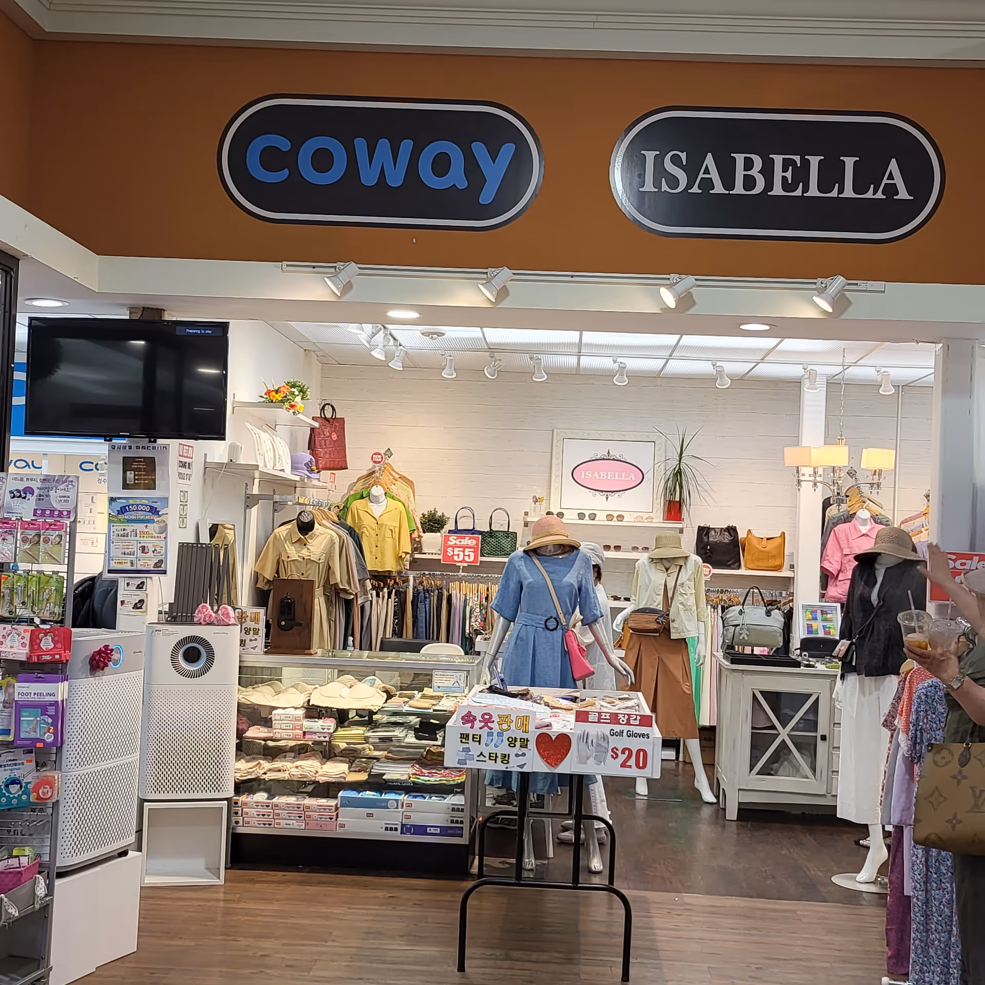 Interior view of a clothing store with mannequins, racks, and sale signage.