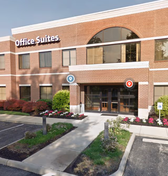 Brick exterior building with glass-entry doors and landscaped front