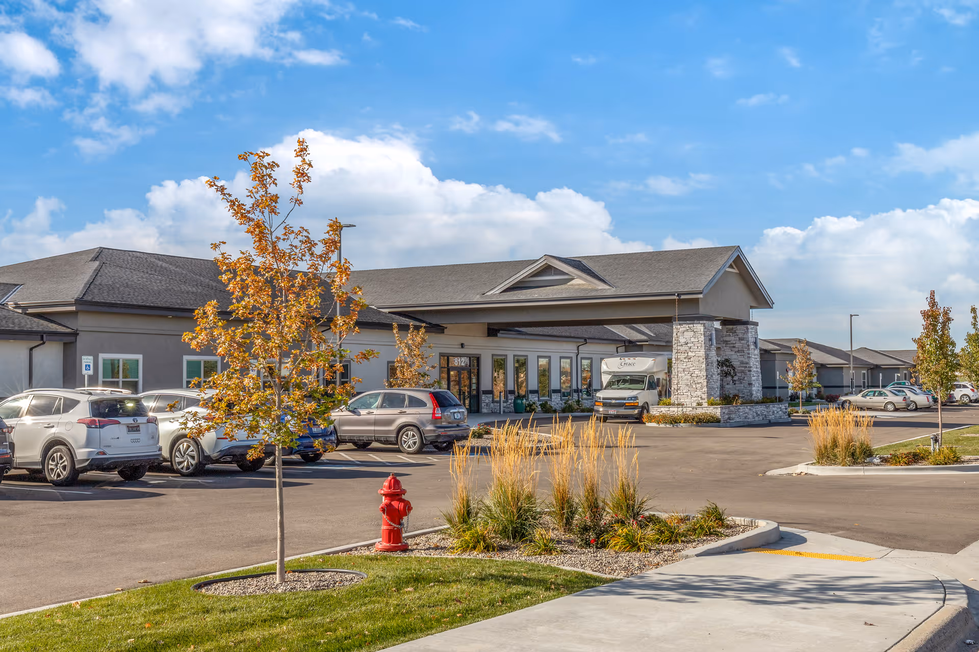 Grace Assisted Living front entrance with parking lot and landscaping under blue sky