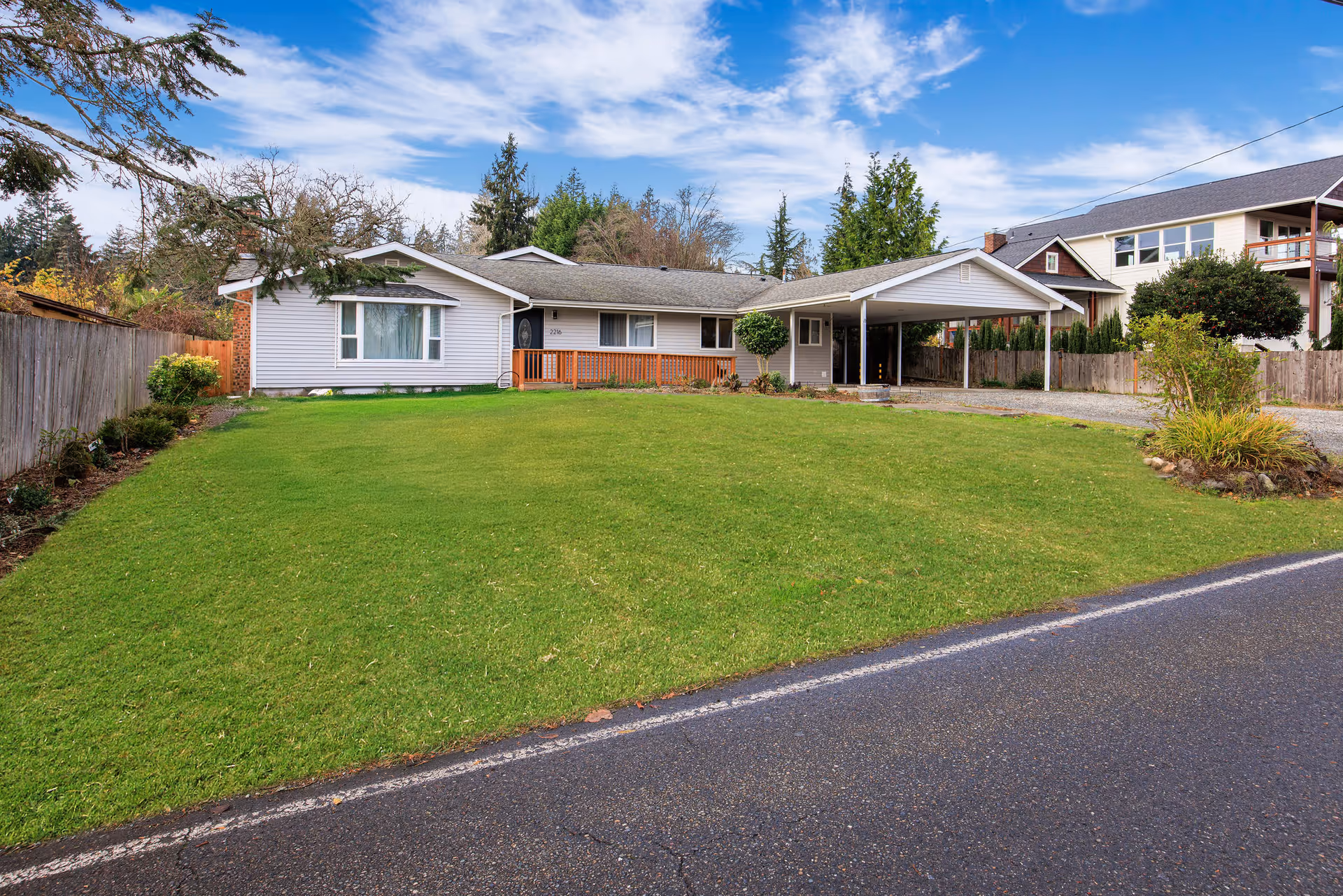 Single-story senior living home with a large front lawn and carport.