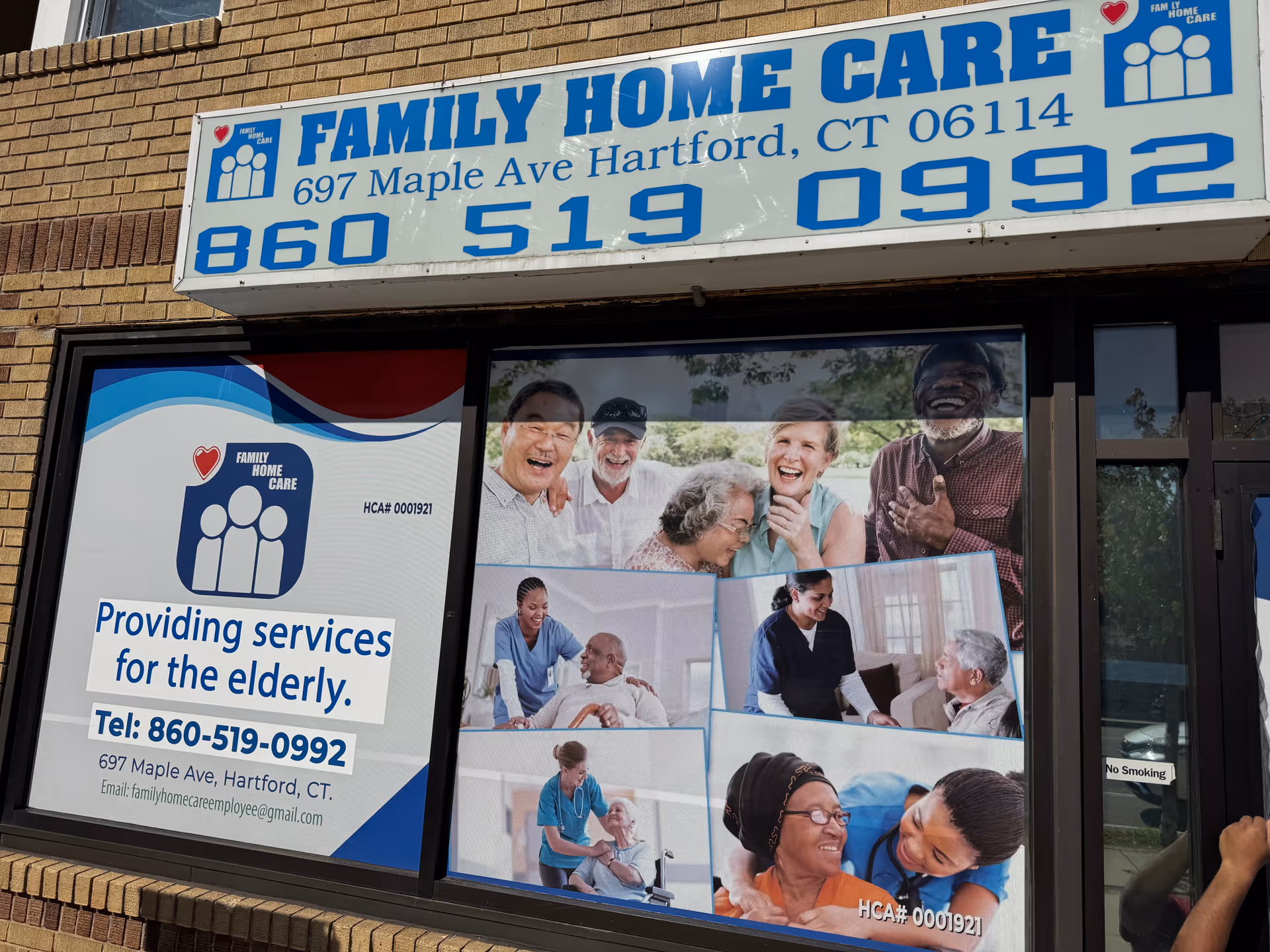 Front of a brick building featuring a large Family Home Care sign and smiling posters.