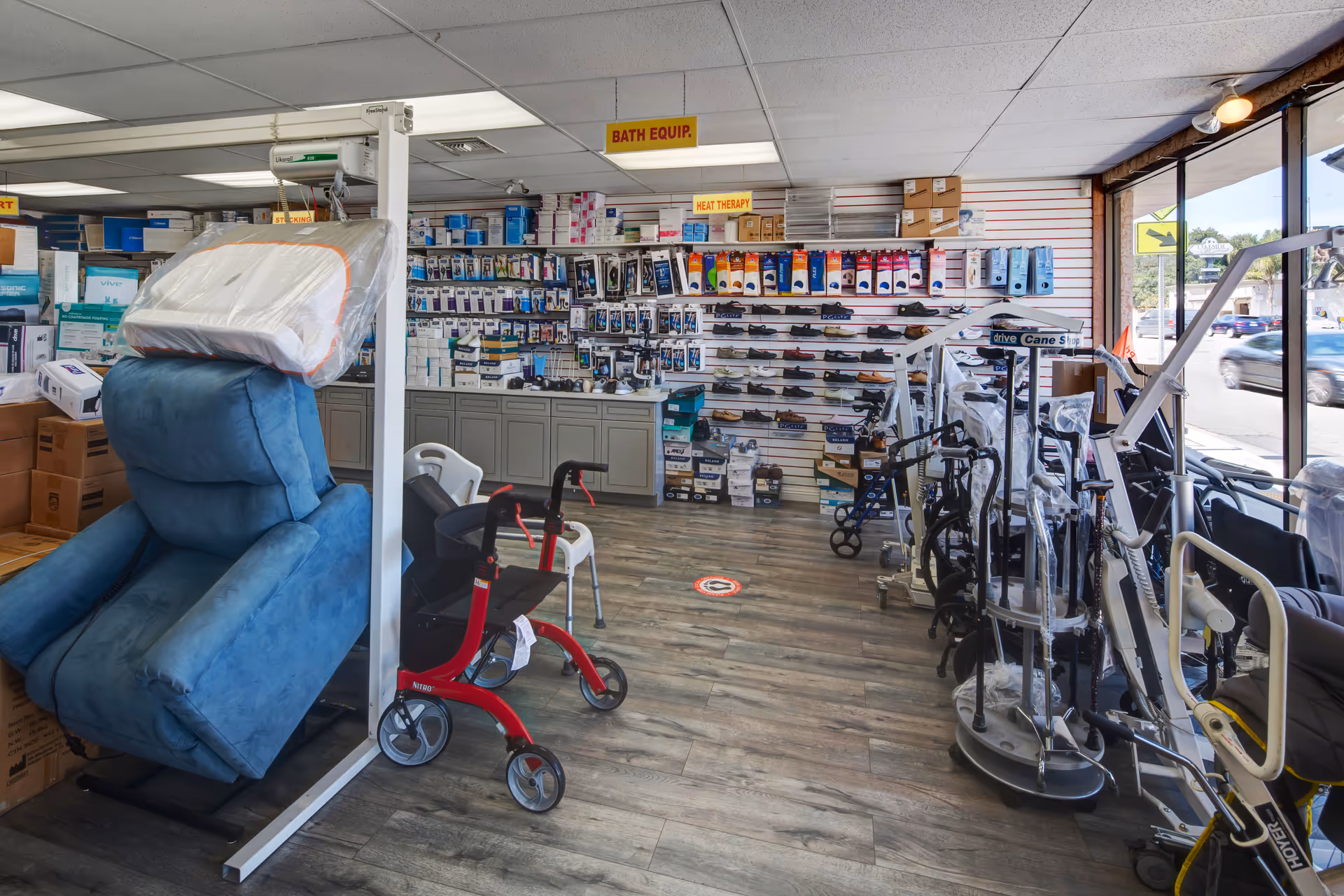 Interior medical supply showroom with mobility aids, chairs, and wall-lined shelves.