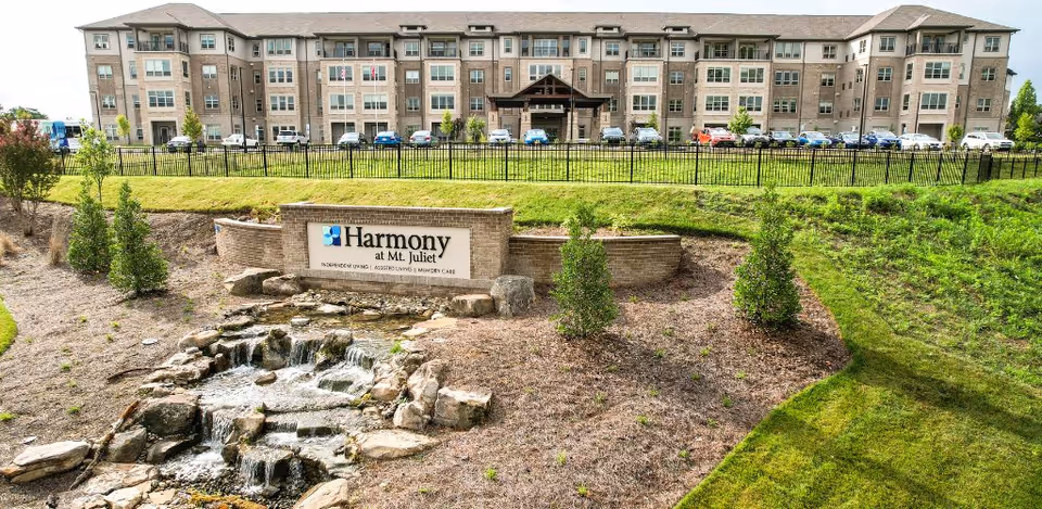 Exterior view of Harmony At Mt. Juliet with sign, water feature, and parking.