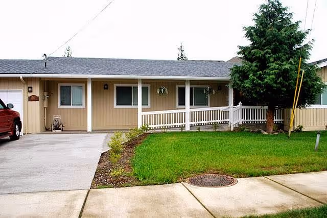 One-story beige senior living home with a covered front porch.