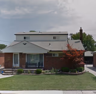 Brick single-story facility with a small front yard, porch, and brick chimney.
