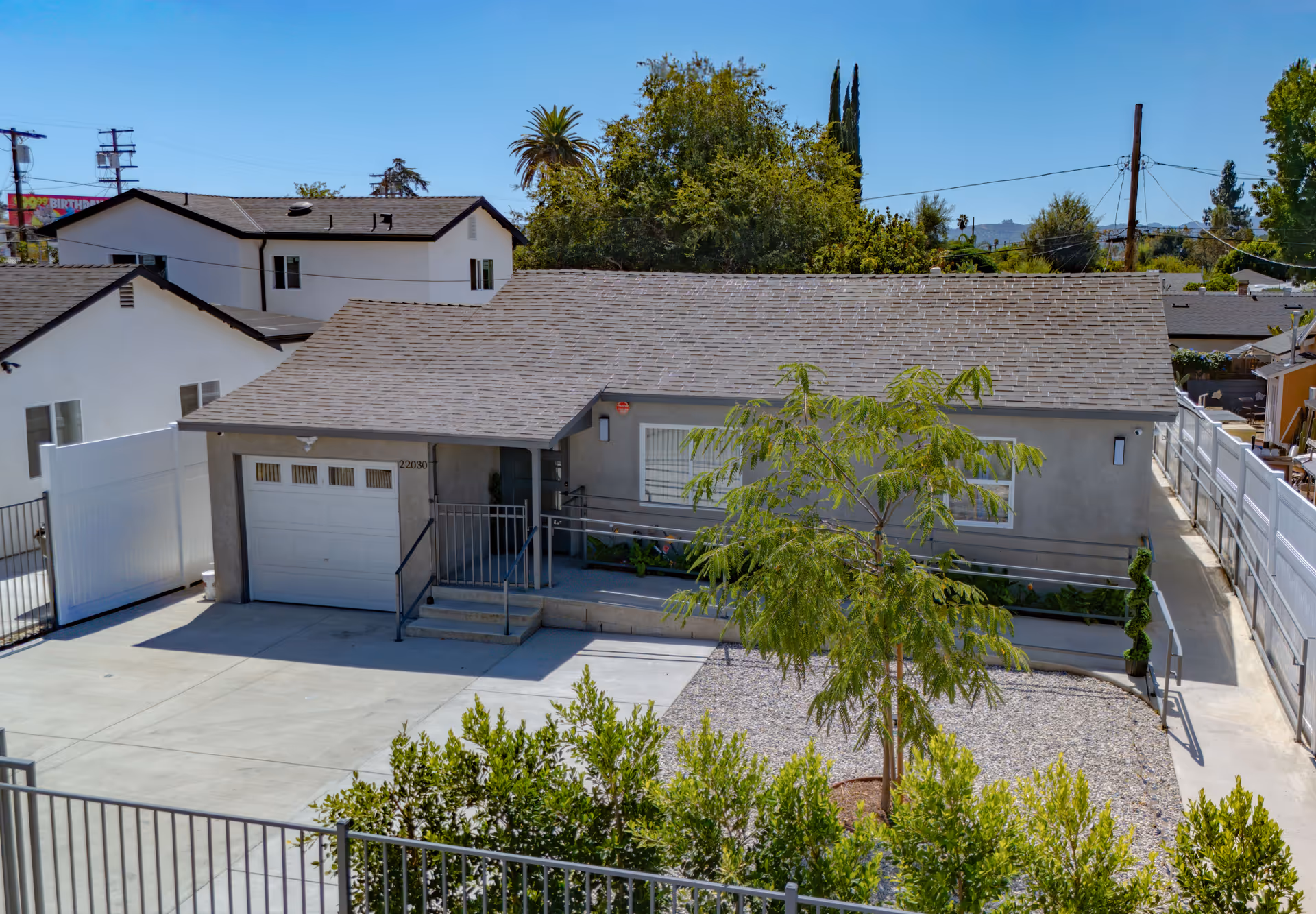 A single-story residential-looking building with a driveway and small front yard.