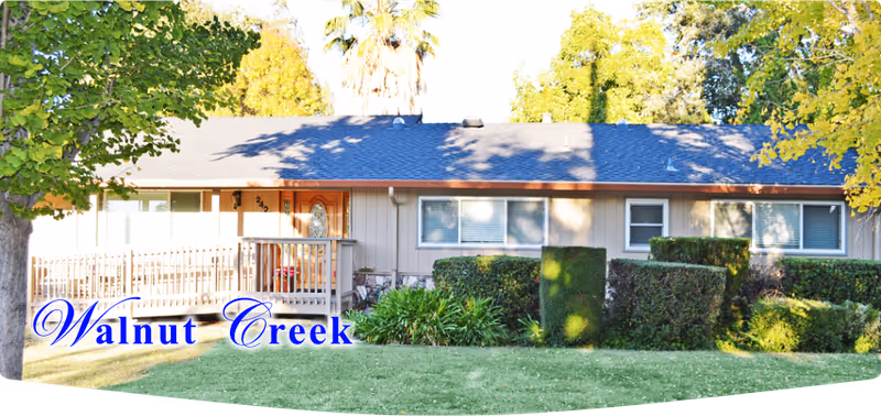 Front view of a single-story senior residence with a manicured lawn and shrubs.