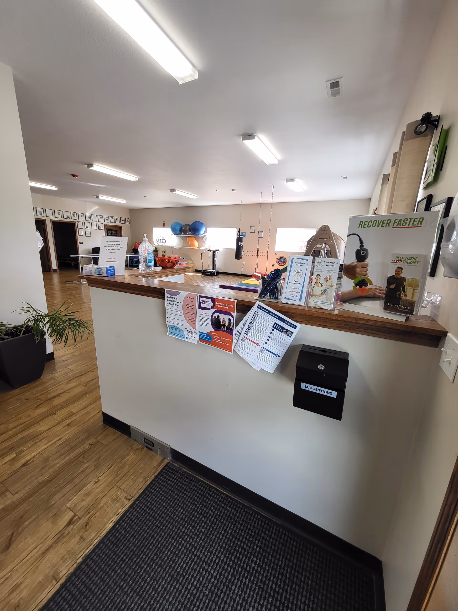 Reception desk at Pure Health Services with brochures and signs in a senior living facility