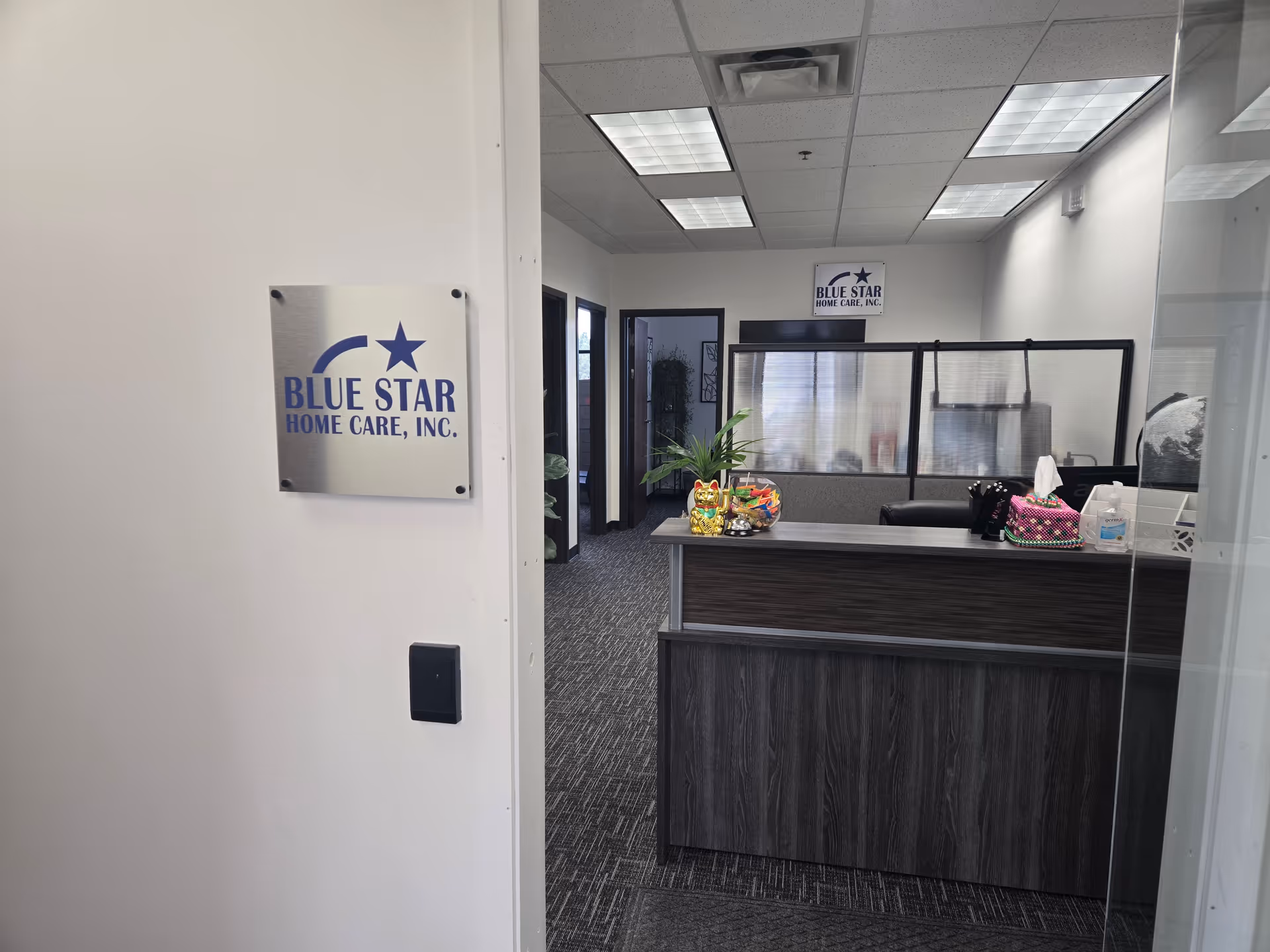 Reception area with a dark wood desk and Blue Star Home Care sign.
