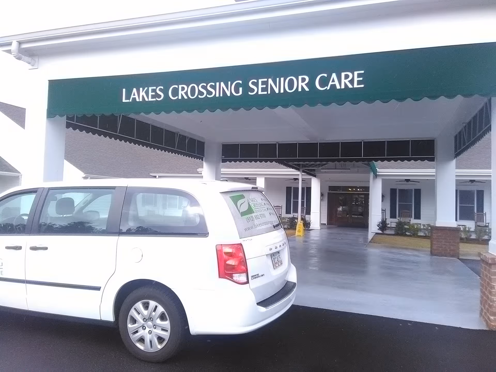 Front entrance of Lakes Crossing Senior Care with a white van parked outside.