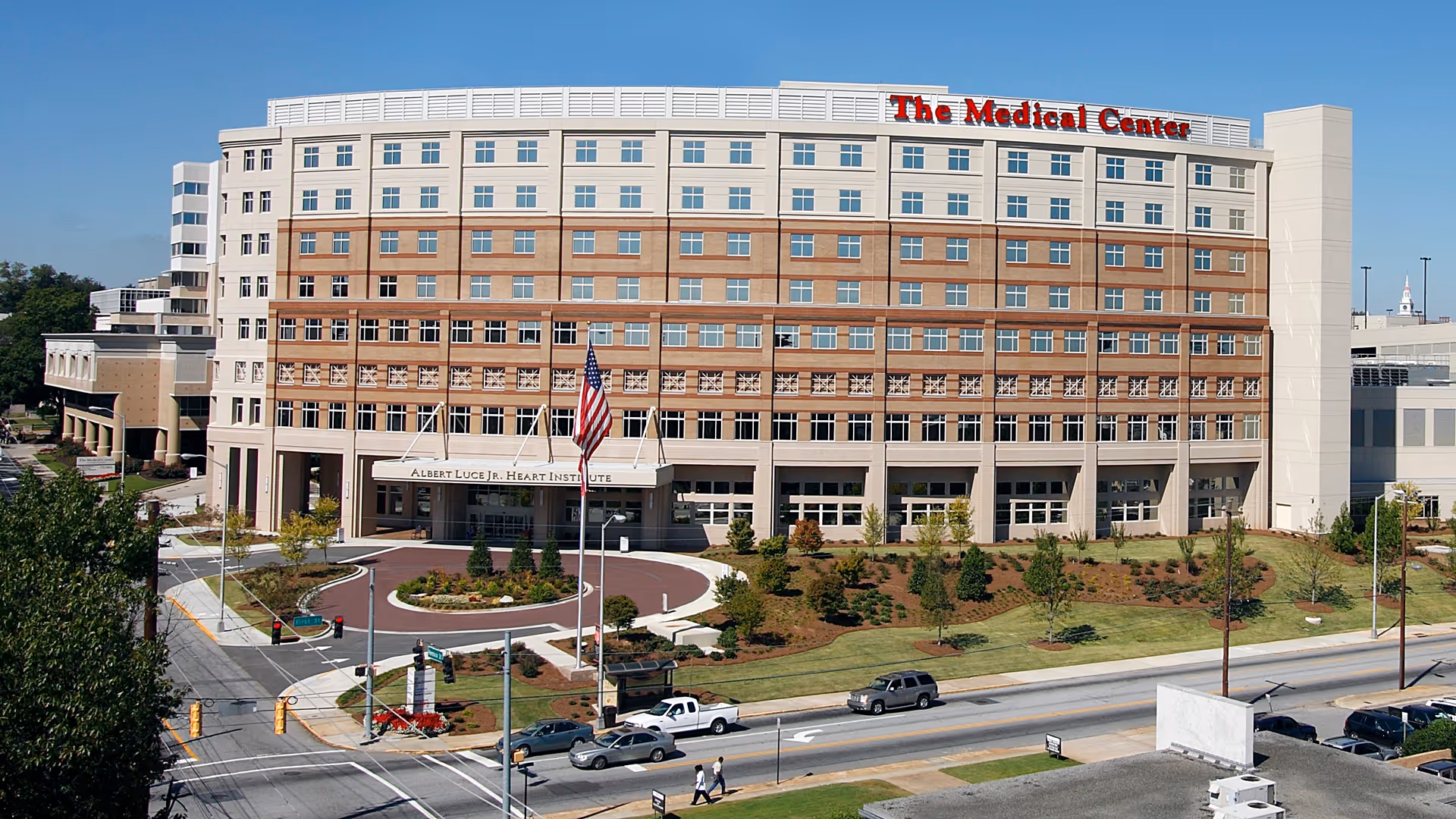 A large multi-story medical center with a circular driveway and landscaped front.