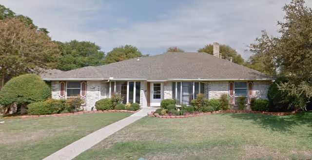 One-story brick building with a manicured lawn and walkway to the front entrance.