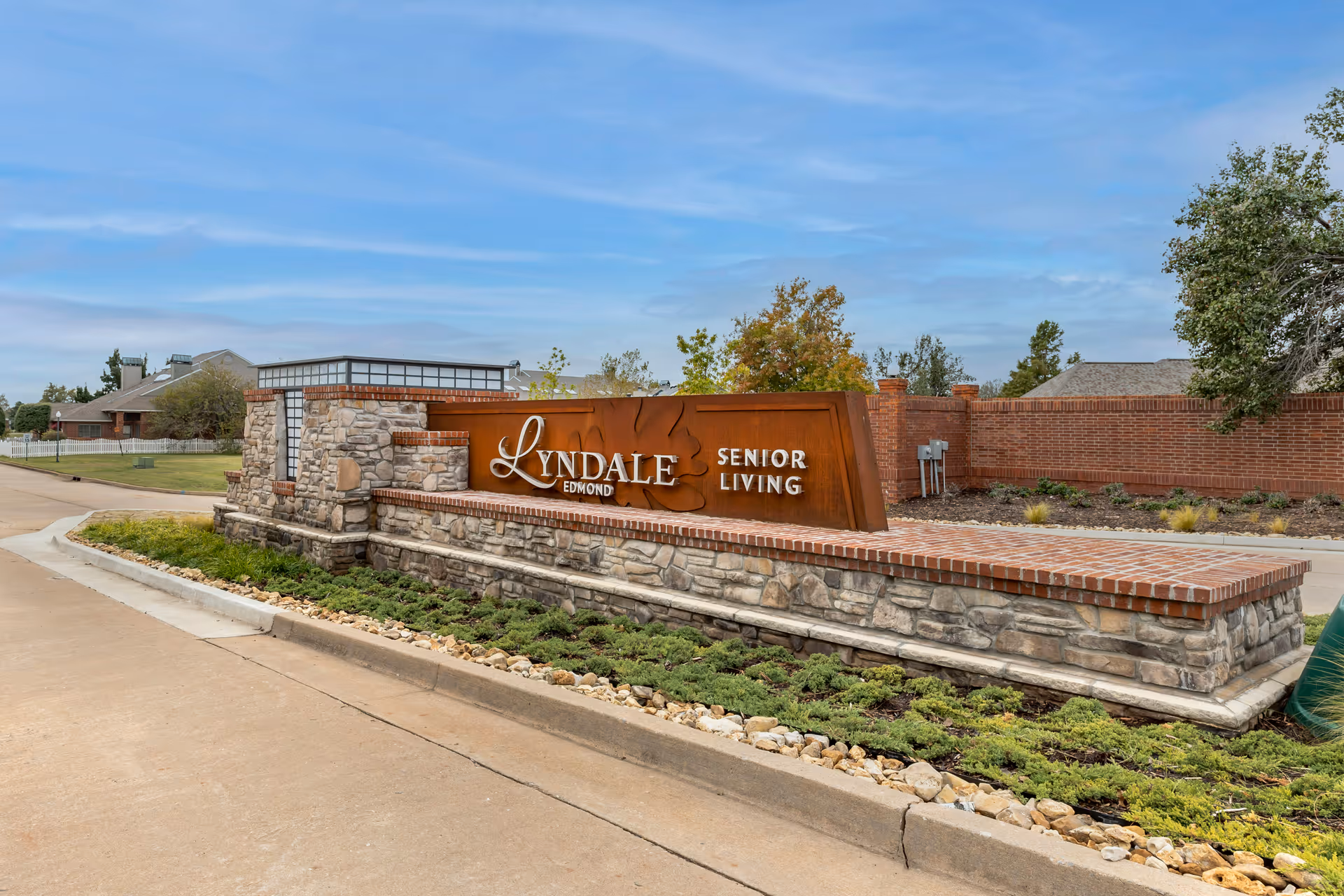Exterior view of Lyndale Edmond Senior Living entrance sign with brick and stone facade.