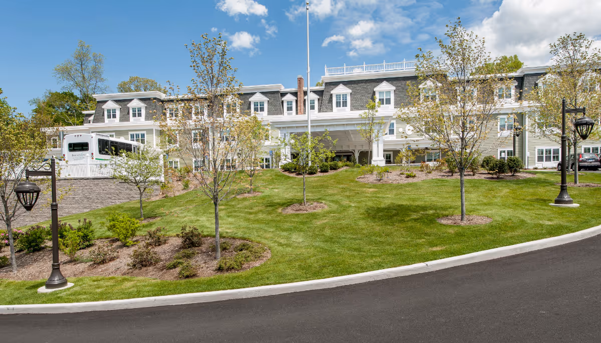 Exterior of Brightview on New Canaan with manicured lawn, trees, and a circular driveway.
