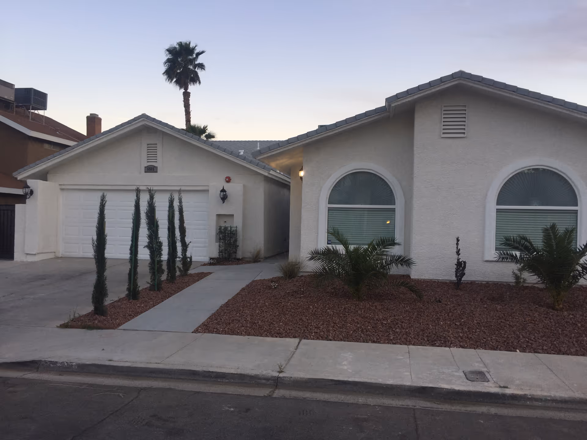 Front exterior of a single-story home with a two-car garage and desert landscaping.