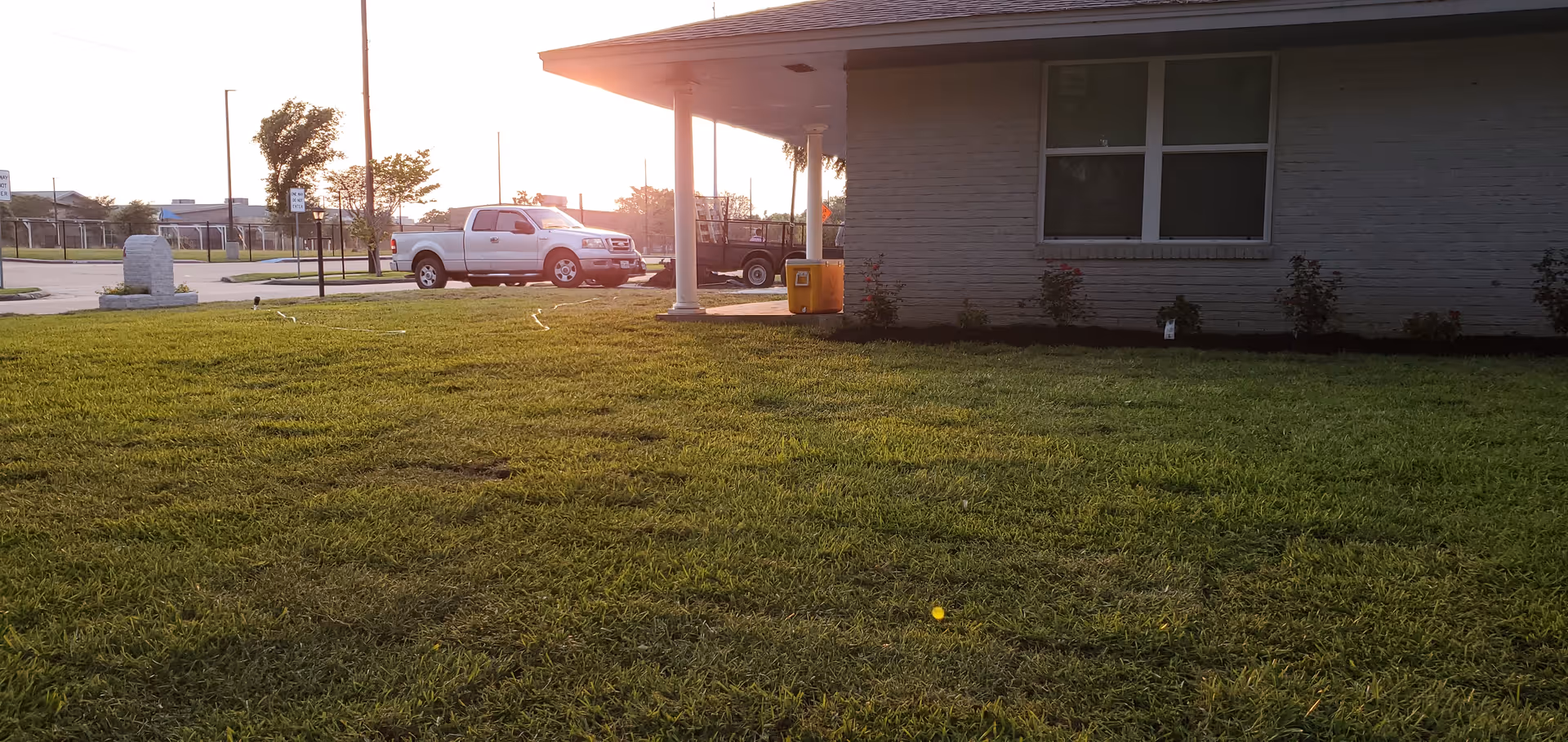 Exterior view of Senior Link Assisted Living building with a grassy front yard and parked cars.