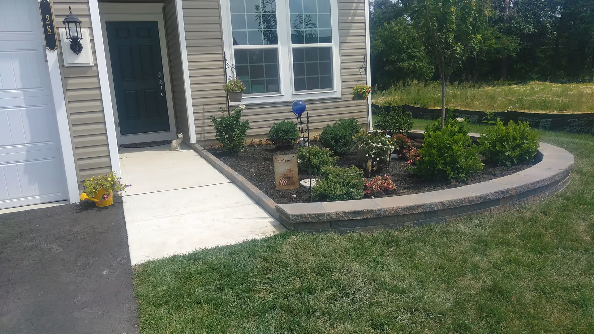 Front entrance of a senior living facility with curved stone garden bed and landscaping.