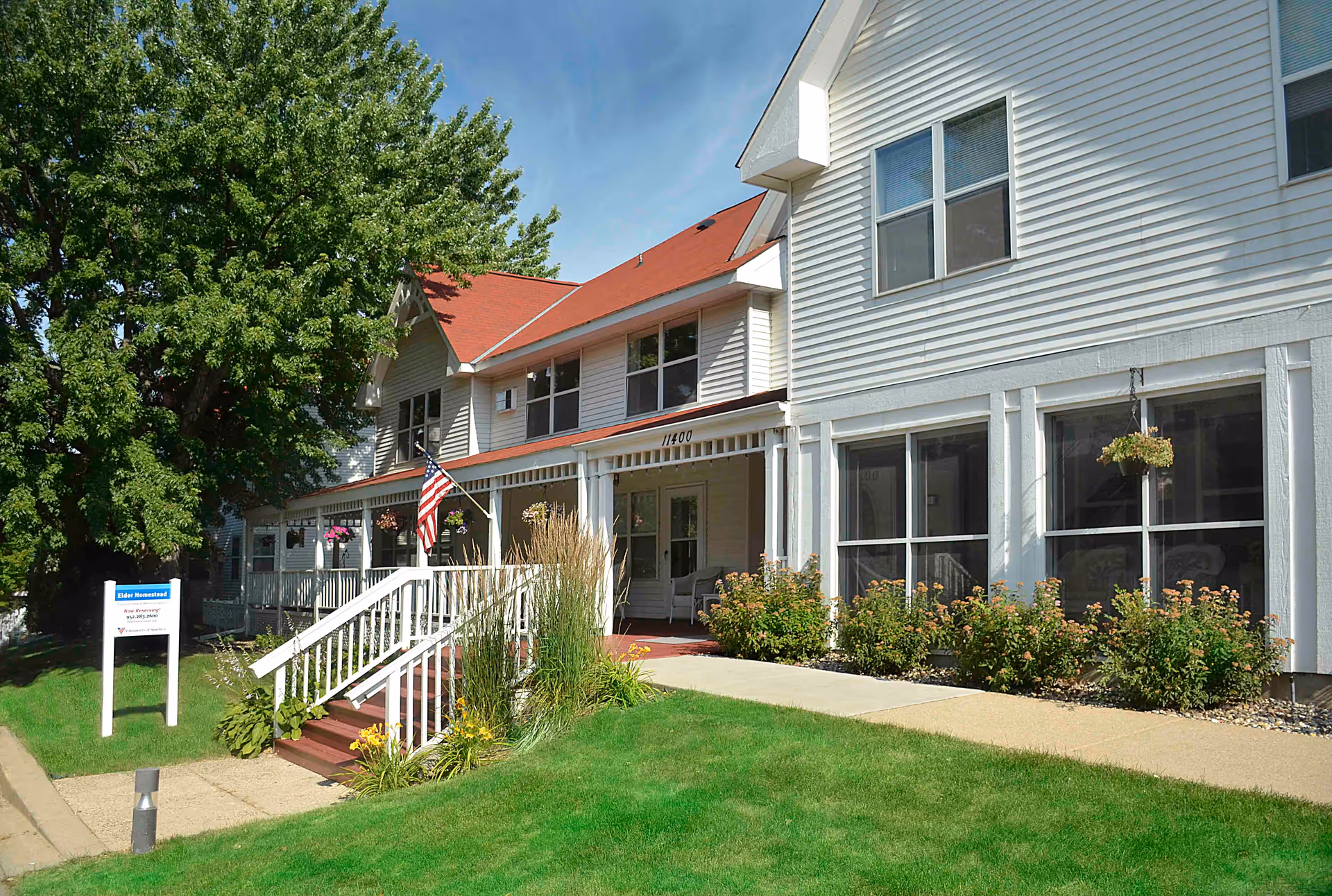 Exterior view of Elder Homestead front entrance with stairs, ramp, and landscaped lawn.