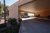 Covered entry driveway leads to Mi Casa Nursing Center with parked cars nearby.